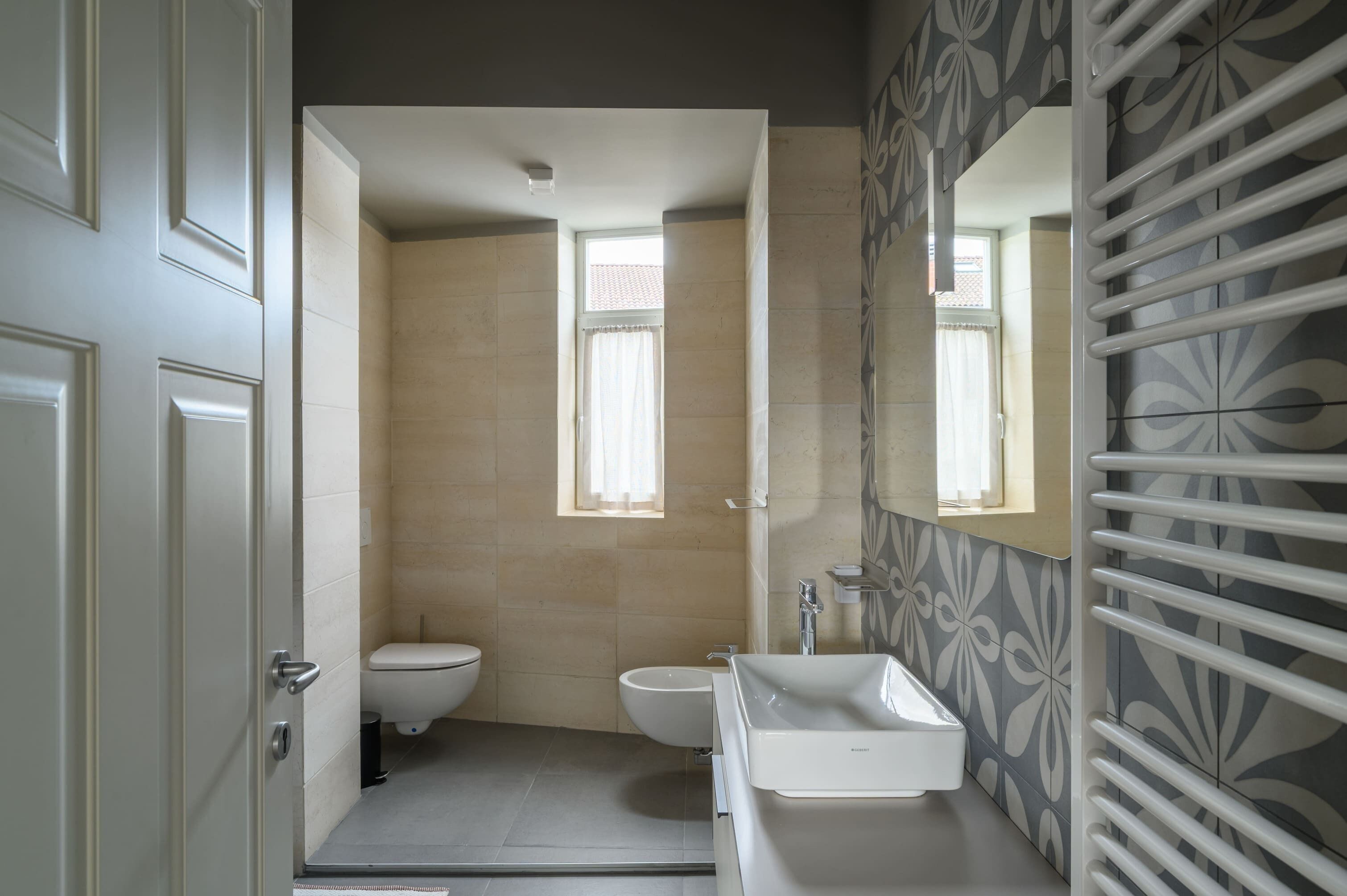 Une salle de bain équipée de toilettes, d’un bidet et d’un lavabo.