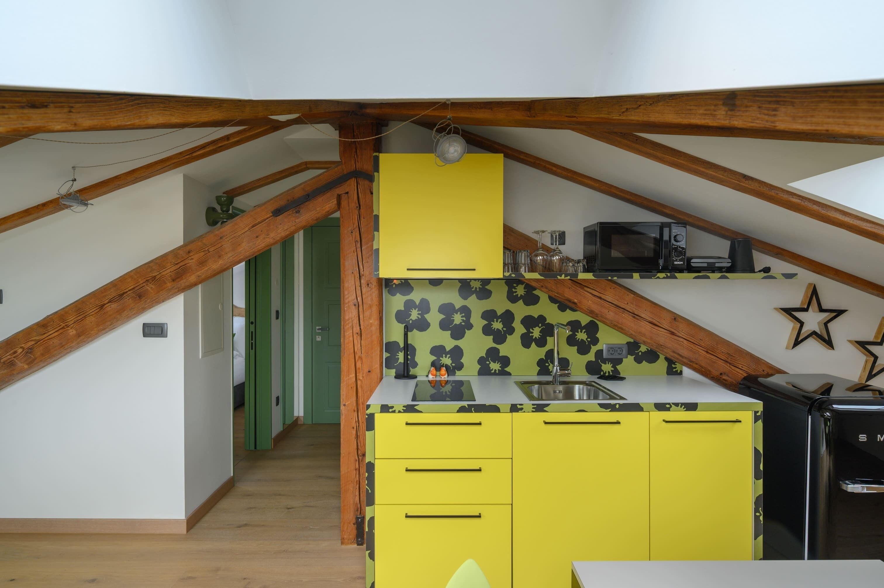 A compact kitchen with yellow cabinets, a microwave, and a sink.