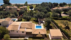 A residential area with houses, a swimming pool, and a view of the sea. - Holiday Home 'Modern Single-story Villa' with Wi-Fi (Mparmpati)