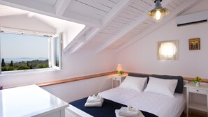 Un dormitorio con cama, mesita de noche, lámpara, ventana con vistas y luz de techo.