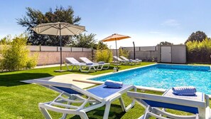 A swimming pool with lounge chairs and umbrellas. - Villa Matošic by Villas Guide (Medulin)