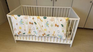 A white crib with a patterned crib sheet. - Room-in the Heart of the City of Salzbur (Salzburg)