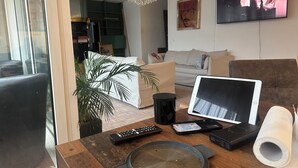A living room with a wooden coffee table, a TV, a couch, and a plant. - Room-in the Heart of the City of Salzbur (Salzburg)