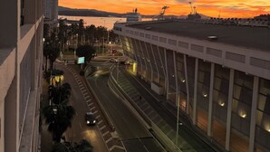 Una vista d'una ciutat costanera al capvespre, amb un pont i infraestructures de carretera.