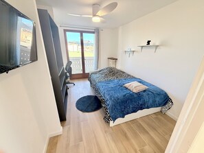 A bedroom with a bed, a desk, a chair, a ceiling fan, and a view of the outdoors. - Upscale 4-bedroom apartment with large balcony (Toulon)