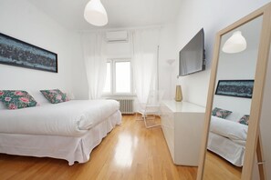 A bedroom with a bed, a desk, a chair, a large mirror, and a window. - Nice flat with Patio near Vatican (roma)