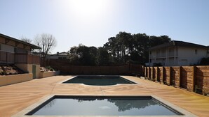 A swimming pool with a wooden deck and a brick wall. - 300 m from beach. Comfort, terrace, wifi, bed linen, garden, swimming pool, parking lot (Moliets-et-Maa)