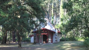 A small, rustic cabin with a red roof and stone walls, surrounded by dense forest. - 300 m from beach. Comfort, terrace, wifi, bed linen, garden, swimming pool, parking lot (Moliets-et-Maa)