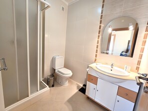 A bathroom with a shower, toilet, sink, and vanity. - Muscari Apartment, Portimão, Algarve (Portimão)