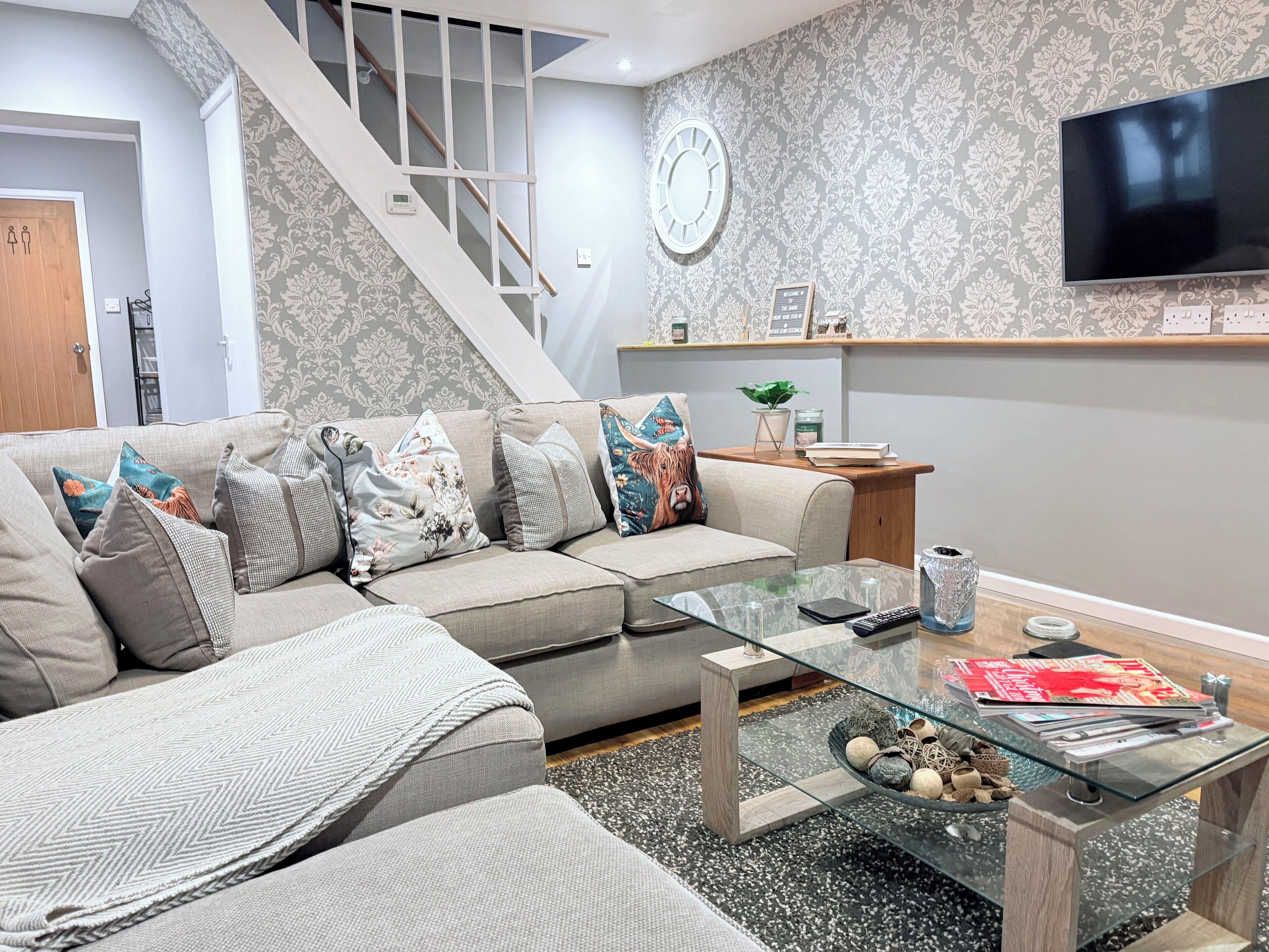 A living room with a sofa, coffee table, and a staircase.