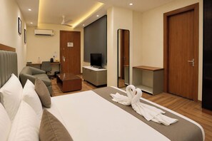 A hotel room with a bed, a desk, a television, and a mirror. - S by Z Hotels, Baani Square (Gurugram)