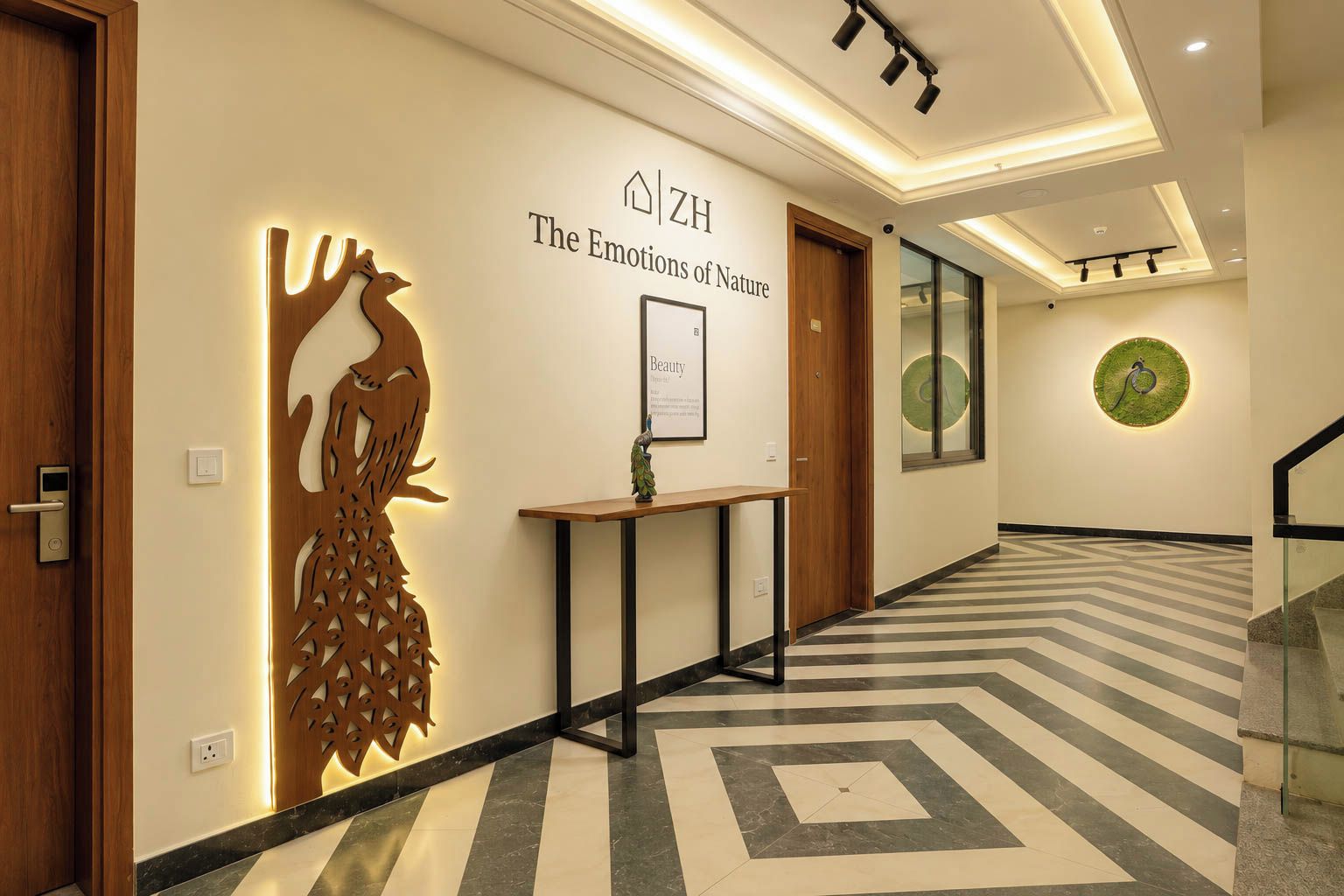 A hotel hallway with a wooden door, a wall-mounted decorative piece, a framed sign, and a patterned floor.