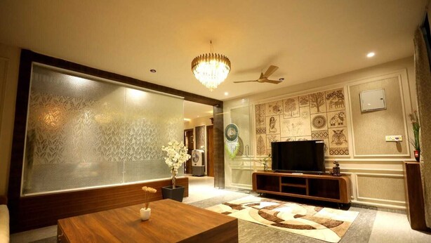 Un soggiorno moderno con un grande televisore, mobili in legno, una parete decorativa e una ventola a soffitto.