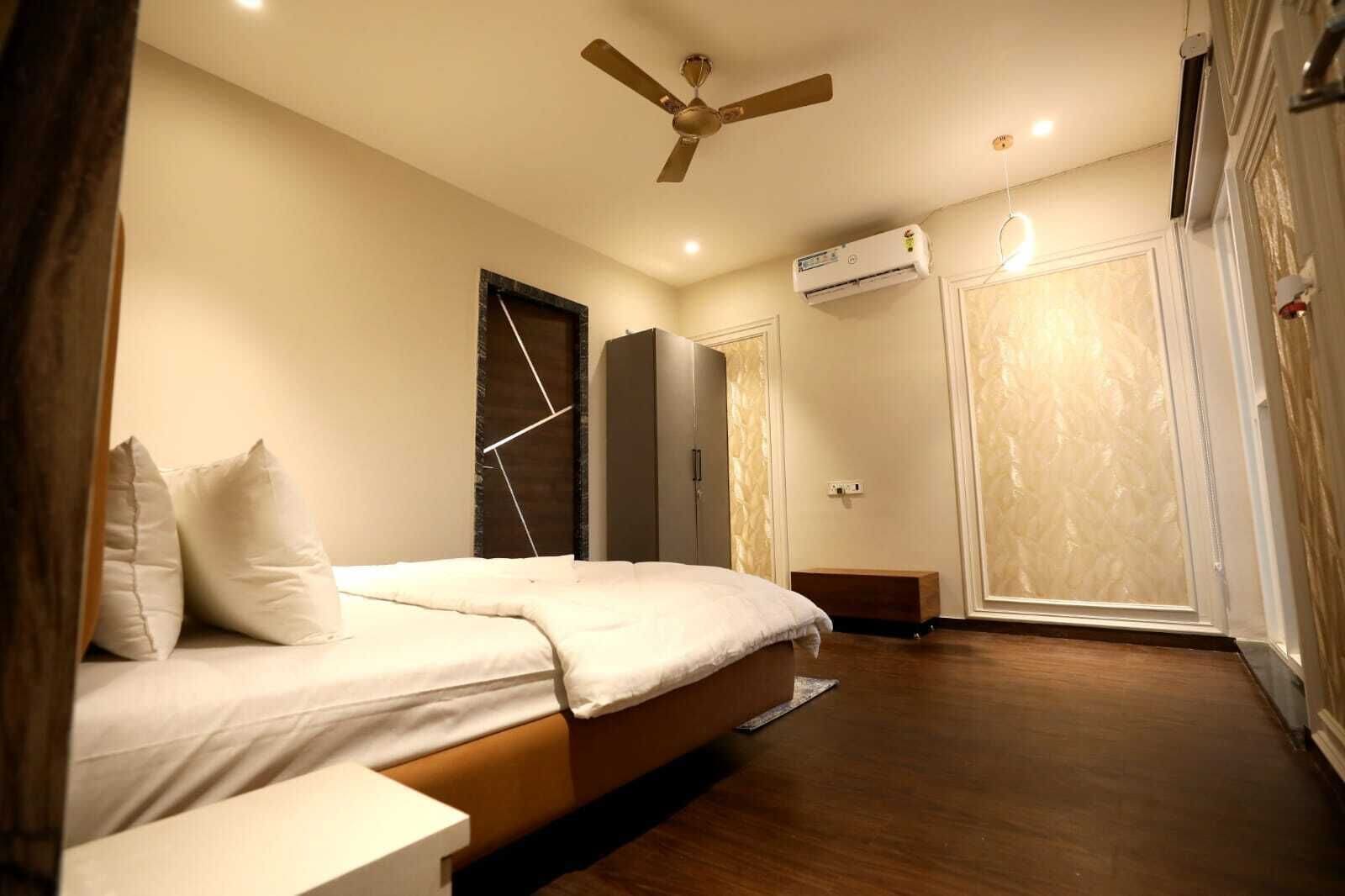 Ein Schlafzimmer mit Bett, Deckenventilator, Klimaanlage und Kleiderschrank.