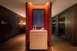 Et moderne badeværelse med et vaskearrangement, et spejl og en skål med frugt.