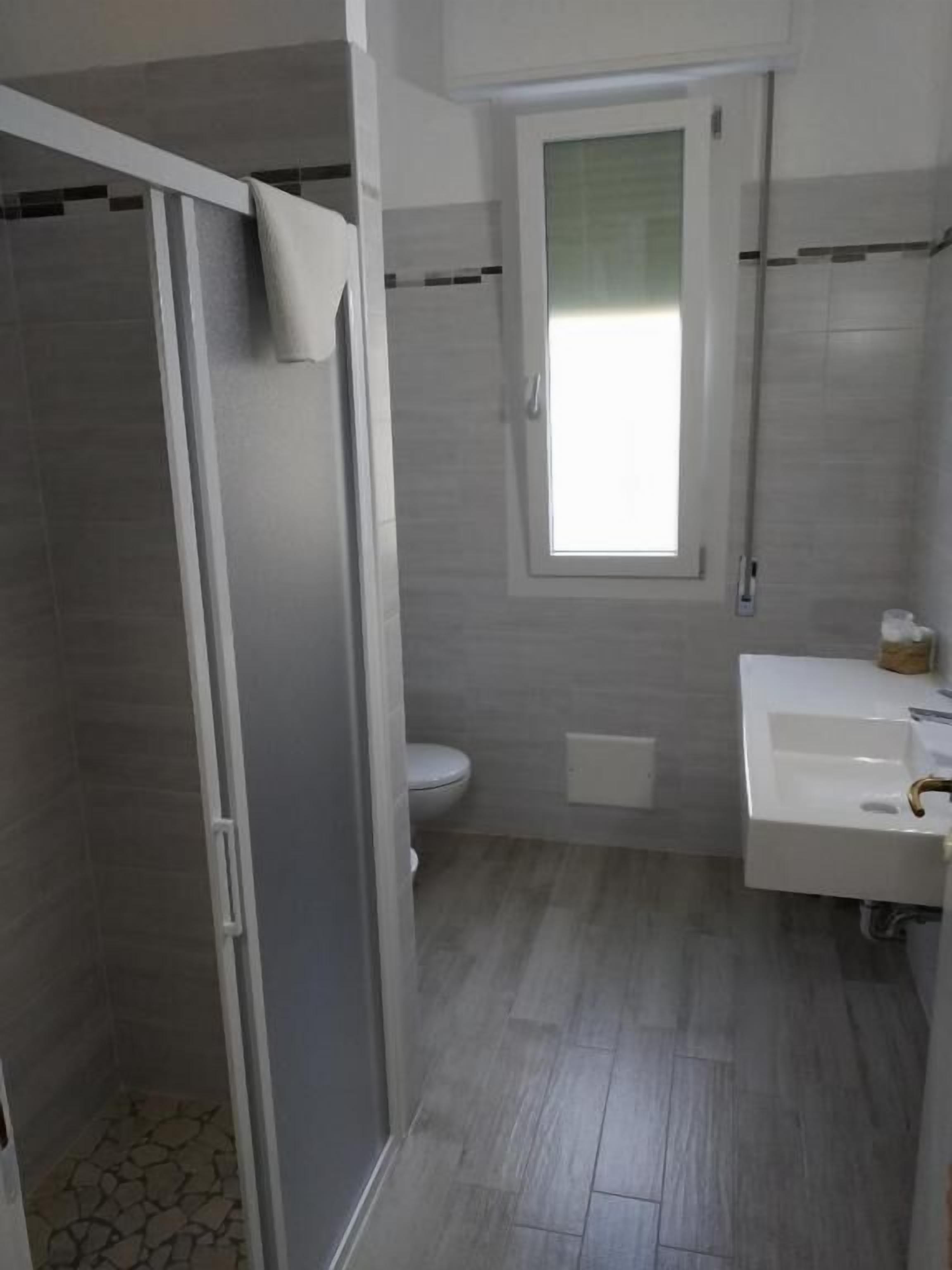 A bathroom with a shower, toilet, and sink.