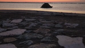 A rocky beach with a small island in the distance. - Hotel Otello (Punta Marina)
