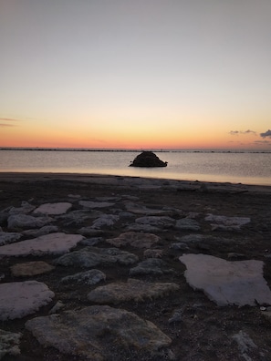 A rocky beach with a small island in the distance. - Hotel Otello (Punta Marina)