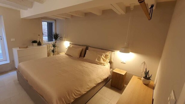 A bedroom with a large bed, bedside tables, a window, and a small desk area. - Dimore del Borgo Antico Corte da Lezze Luxury House Venice (Venezia)