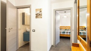 A modern bedroom with a wooden bed, a bedside table, and a hanging light fixture. - Cosy apartment for 4 people with WIFI, TV, balcony and pets allowed (Scalcoggia)