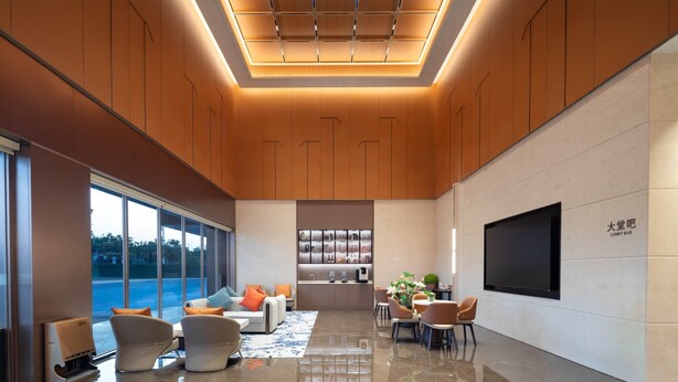 A modern lobby with a seating area, a kitchen, and a large TV screen. - Ramada by Wyndham Zhaoqing Dawang (Zhaoqing)