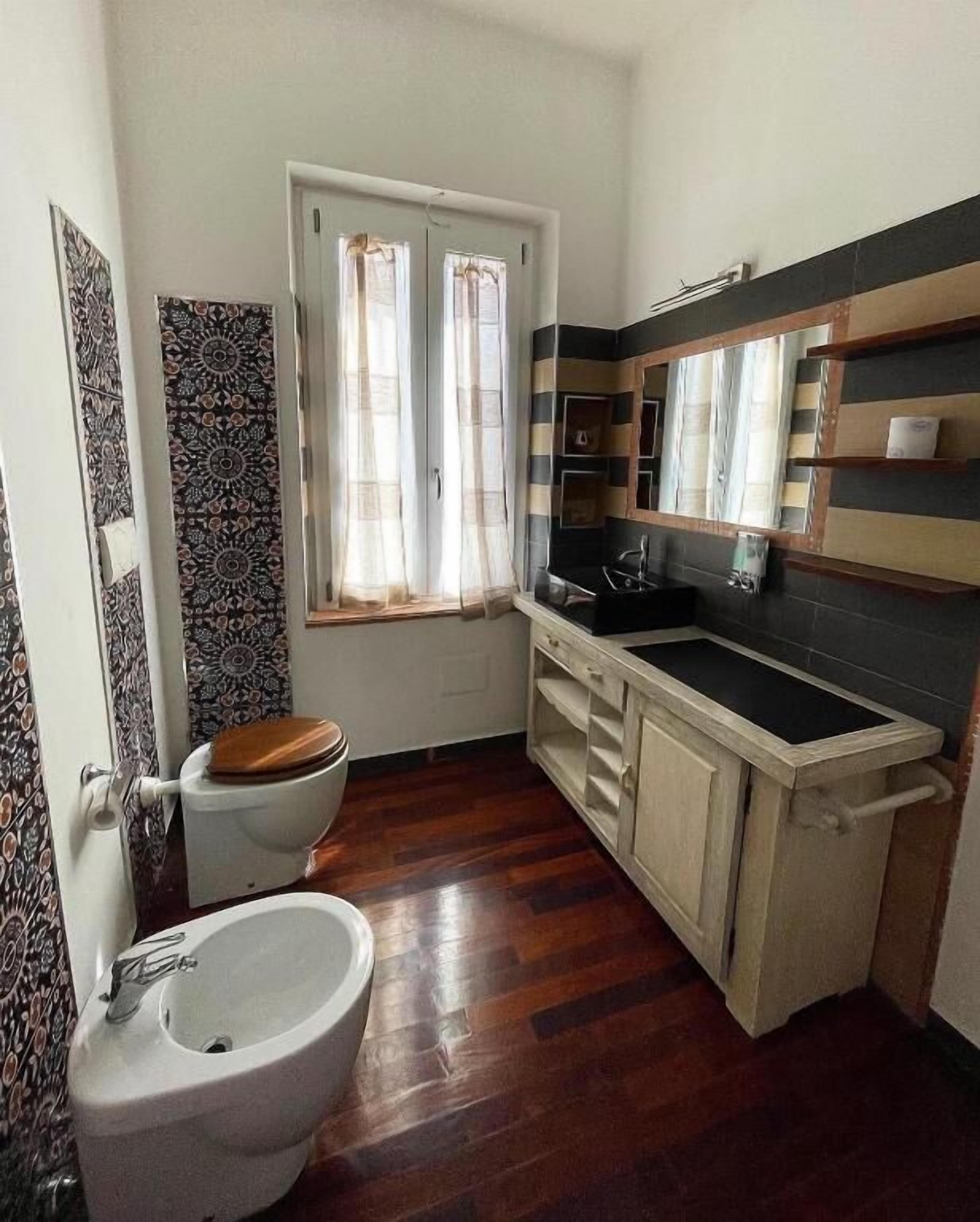 Une petite salle de bain comprenant des toilettes, un bidet et un lavabo.