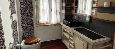 A compact bathroom with a toilet, bidet, and a sink.