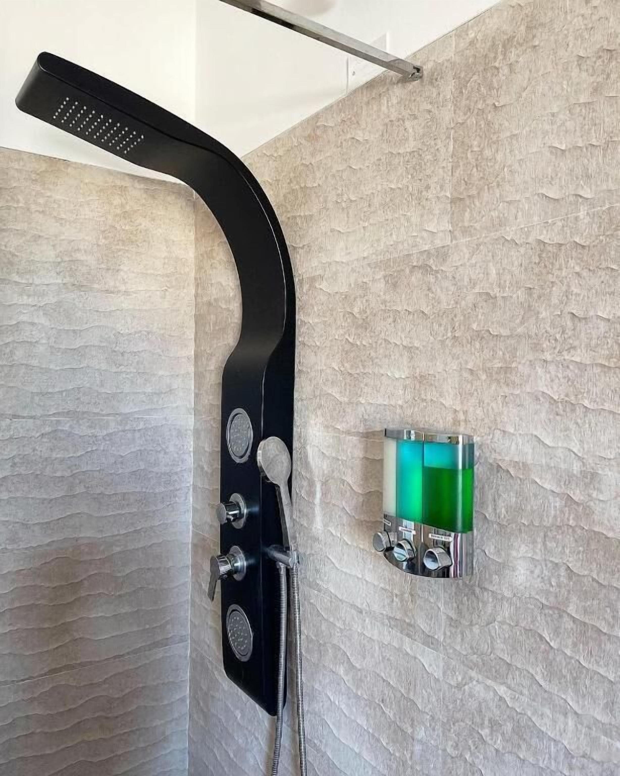 Een moderne douche met een gebogen zwarte kraan, een handdouche en een bedieningspaneel aan de muur.