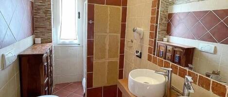 A bathroom with two sinks, a toilet, and a shower area.