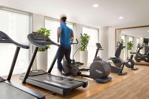 A gym with treadmills, elliptical machines, and stationary bikes. - The First Collection Marina (Dubai)