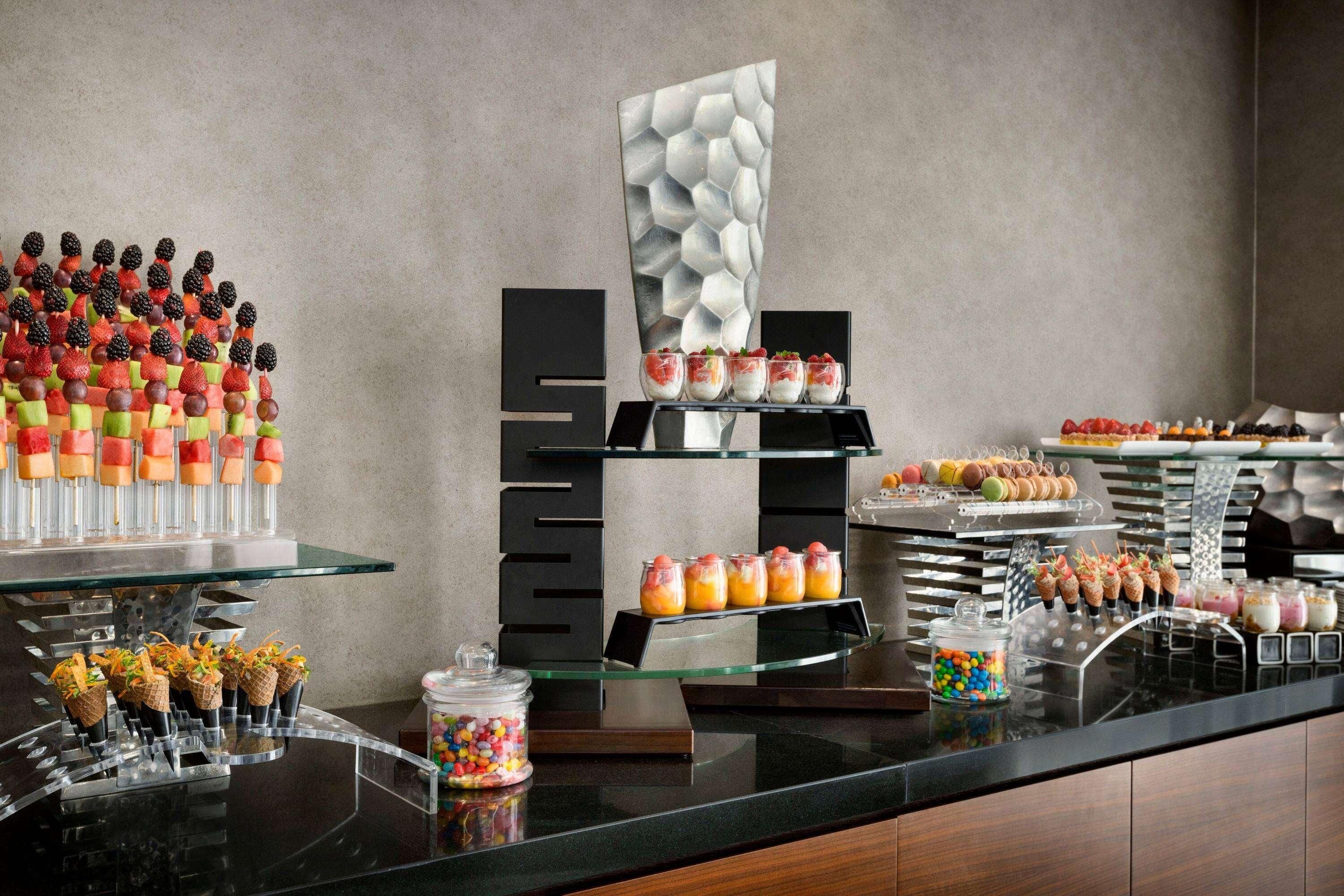 Ein reichhaltiges Buffet mit Speisen und einem dekorativen Wandbild.
