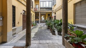 A narrow courtyard with stone flooring, potted plants, and a central pathway leading to a door. - PONTACCIO, 4 - LIVING IN BRERA, IN THE HEART OF MILAN (Milan)
