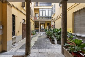A narrow courtyard with stone flooring, potted plants, and a central pathway leading to a door. - PONTACCIO, 4 - LIVING IN BRERA, IN THE HEART OF MILAN (Milan)