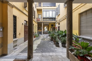 A narrow courtyard with stone flooring, potted plants, and a central pathway leading to a door. - PONTACCIO, 4 - LIVING IN BRERA, IN THE HEART OF MILAN (Milan)