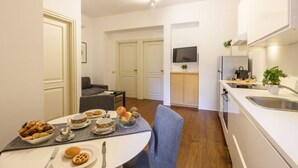 A modern kitchen with a dining area, a flat-screen TV, and a small seating area. - PONTACCIO, 4 - LIVING IN BRERA, IN THE HEART OF MILAN (Milan)