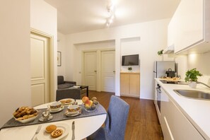A modern kitchen with a dining area, a flat-screen TV, and a small seating area. - PONTACCIO, 4 - LIVING IN BRERA, IN THE HEART OF MILAN (Milan)