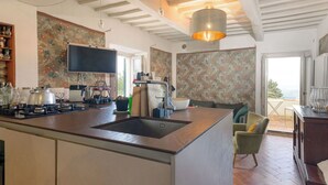 Una cucina moderna con isola centrale, piano cottura integrato e un'ampia finestra con vista panoramica.