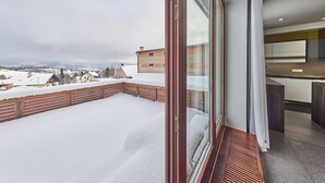 A balcony with a view of a snowy landscape and a modern kitchen. - Cosy apartment for 6 guests with WIFI, TV and terrace (Turnov)