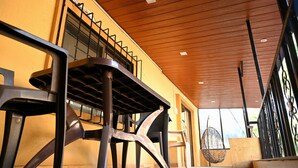 Ein moderner Außenbereich mit Holzboden, Metalltreppe und Korbsessel.