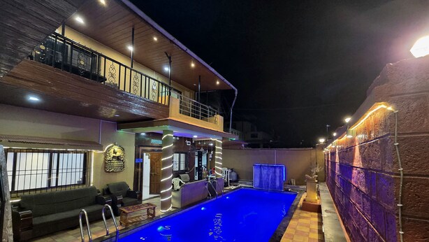 Ein Swimmingpool mit blauer Innenauskleidung, umgeben von einem Schachbrettboden, und ein Balkon mit Geländer.