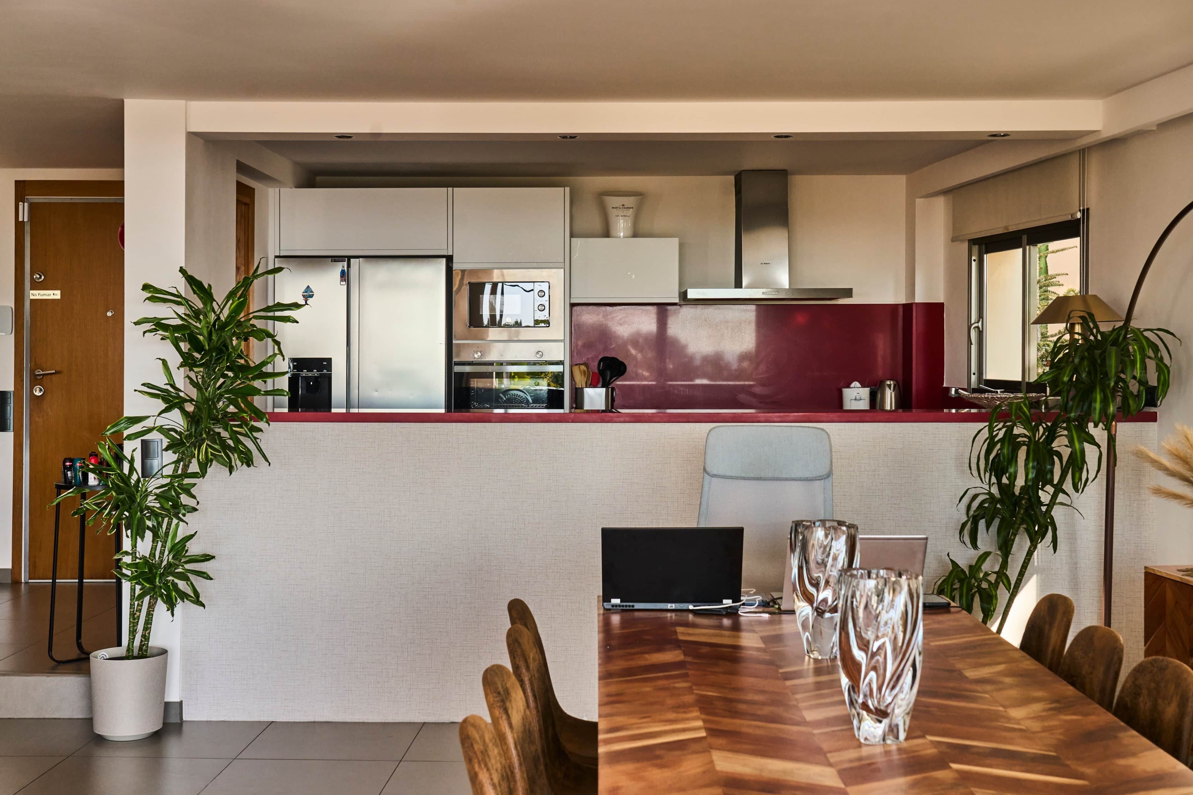 A modern kitchen with a central island, a dining area with a wooden table, and a seating arrangement.