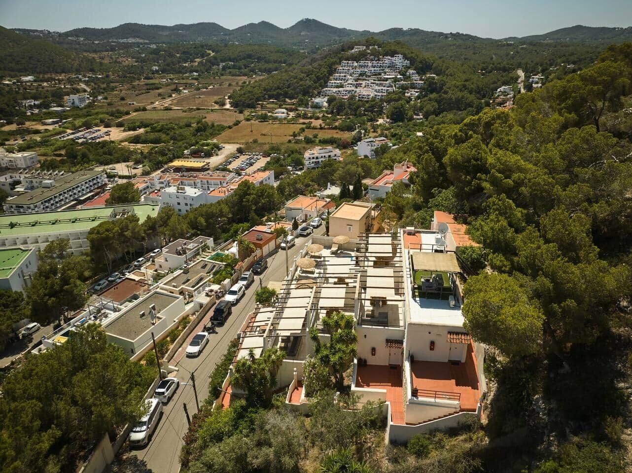 An aerial view of a residential area with houses, roads, and greenery.