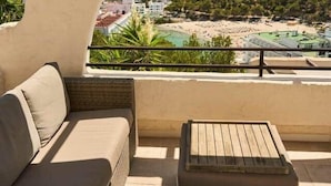 An outdoor seating area with a view of a beach and mountains. - Apartment nº7, 1 bedroom, 1 bathroom (Cala Llonga)