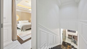 Eine Treppe führt zu einem Schlafzimmer mit einem Bett, einem Schreibtisch und einem Stuhl.