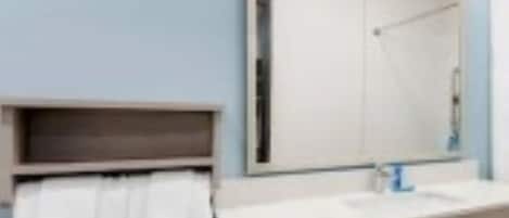 A bathroom with a white sink, a mirror, and a towel rack.