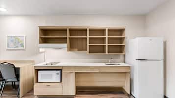 Una cucina moderna con mobili in legno, un frigorifero bianco e un forno a microonde.