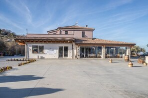 A two-story building with a tiled roof, large glass windows, and a sign that reads "grave." - Tenuta Giave - Camera Tripla 6 (Montemarano)