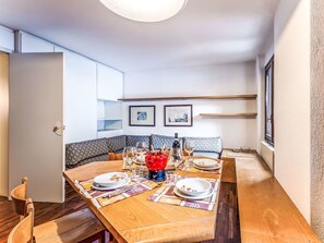 A dining area with a wooden table set for four, a bench, and a view of the room. - Beautiful apartment for 4 people with WIFI, TV and pets allowed (Madesimo)