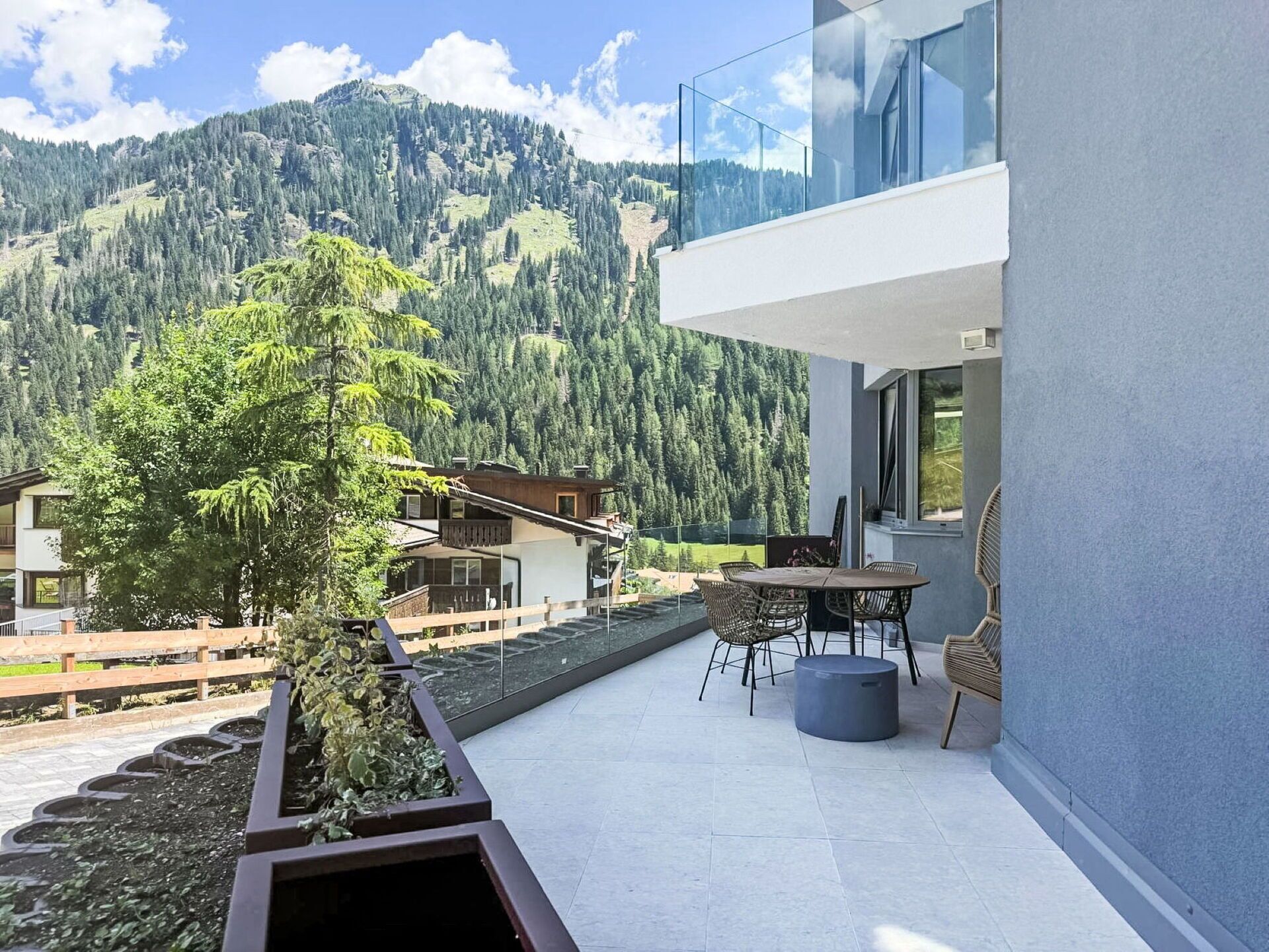 Een modern gebouw met een balkon met uitzicht op een bergachtig landschap.