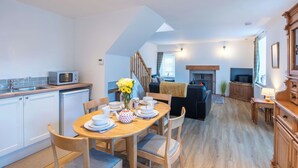 A modern kitchen with a dining area, a living room with a fireplace, and a TV. - Wonderful private villa for 4 guests with WIFI, TV and pets allowed (Inverness)